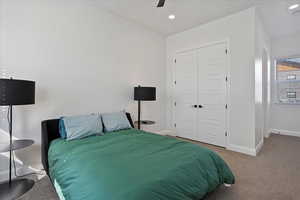 Carpeted bedroom with ceiling fan, baseboards, a closet, and recessed lighting