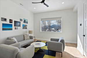 Living area featuring recessed lighting, a ceiling fan, visible vents, baseboards, and light wood-type flooring