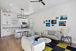 Living area featuring light wood-style flooring, recessed lighting, visible vents, and baseboards