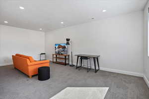 Living area featuring carpet floors, baseboards, visible vents, and recessed lighting