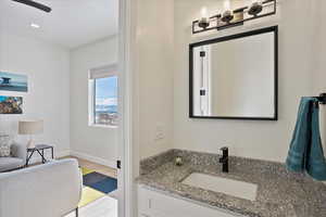 Bathroom with vanity, baseboards, and wood finished floors