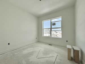 Empty room featuring baseboards, visible vents, and a textured ceiling