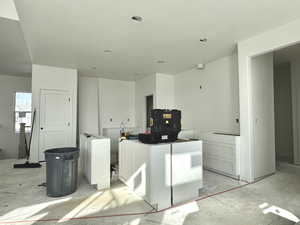 Kitchen featuring a kitchen island, white cabinetry, and a textured ceiling