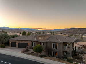 Mediterranean / spanish home with driveway, an attached garage, a tile roof, and a mountain view