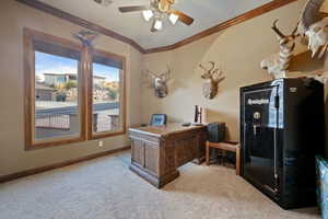 Office area with baseboards, visible vents, light colored carpet, ceiling fan, and ornamental molding