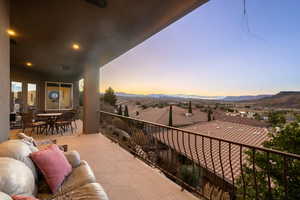 Balcony at dusk featuring a residential view, a mountain view, and outdoor dining area