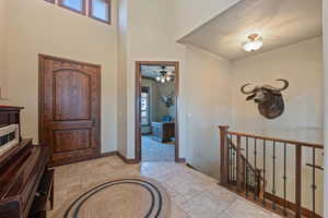 Foyer entrance with a high ceiling, baseboards, and stone tile floors