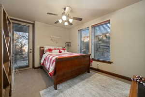 Carpeted bedroom featuring a ceiling fan, access to outside, multiple windows, and baseboards