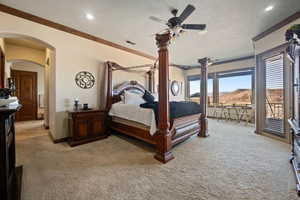 Bedroom featuring arched walkways, access to outside, light carpet, and a mountain view