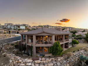 Rear view of house with a residential view, a tile roof, and a patio