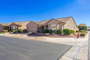 Mediterranean / spanish-style home with an attached garage, a tiled roof, concrete driveway, and stucco siding