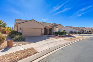 View of front facade featuring stucco siding, concrete driveway, a garage, a residential view, and stone siding