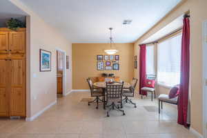 Dining room featuring light tile patterned floors, visible vents, and baseboards