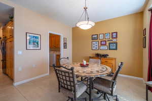 Dining room  with baseboards, and light tile patterned floors. Laundry room off of dining room