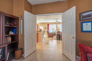 Office off of great room with light tile patterned flooring, a textured ceiling, and baseboards