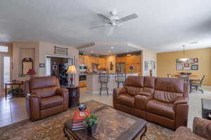 Great room with light tile patterned floors, recessed lighting, visible vents, a textured ceiling, and baseboards