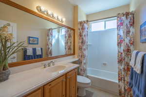 Full 2nd bathroom with toilet, tile patterned floors, shower / bath combination with curtain, and vanity