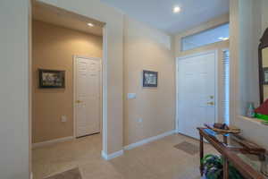 Entrance foyer with light tile patterned floors, baseboards, and recessed lighting