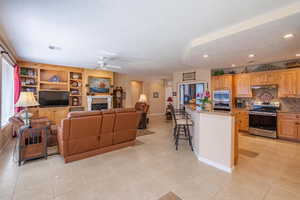 Great room featuring a fireplace, visible vents, light tile patterned flooring, ceiling fan, and a textured ceiling