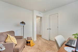 Office area featuring light colored carpet, visible vents, and baseboards