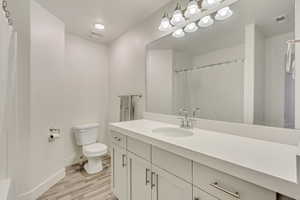 Full bathroom with visible vents, vanity, toilet, and wood finished floors