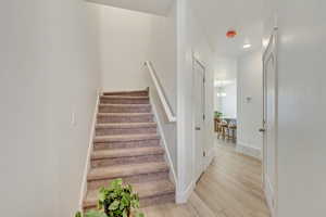 Staircase featuring visible vents, a notable chandelier, baseboards, and wood finished floors