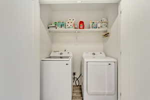 Laundry area featuring wood finished floors and washer and dryer