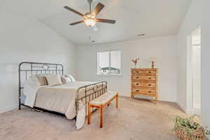 Bedroom featuring light carpet, baseboards, visible vents, lofted ceiling, and ceiling fan