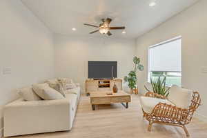 Living area with baseboards, ceiling fan, light wood-style flooring, and recessed lighting