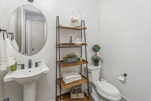 Half bath featuring toilet and baseboards