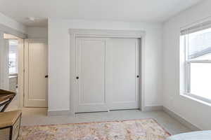 Bedroom featuring a closet, light colored carpet, and baseboards