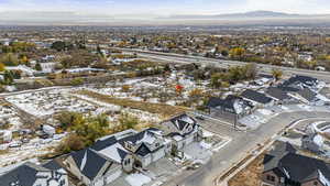 Snowy aerial view featuring a residential view and a mountain view