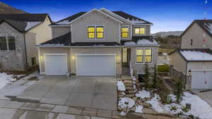 View of front of home featuring a garage, concrete driveway, a mountain view, board and batten siding, and brick siding