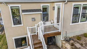 Doorway to property featuring stucco siding