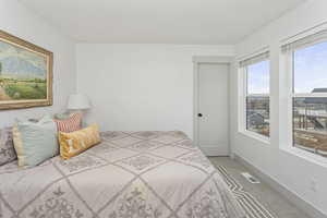 Bedroom with baseboards, visible vents, and carpet flooring