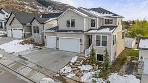 View of front of home featuring a mountain view, a garage, brick siding, driveway, and board and batten siding