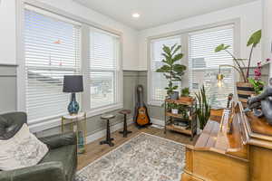 Home office with light wood-style floors, recessed lighting, a decorative wall, and wainscoting