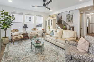 Living area featuring baseboards, ceiling fan, wood finished floors, stairs, and recessed lighting