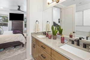 Full bath with double vanity, ensuite bath, a sink, and recessed lighting