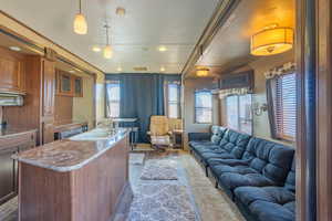 Kitchen with a center island with sink, open floor plan, decorative light fixtures, light countertops, and a sink