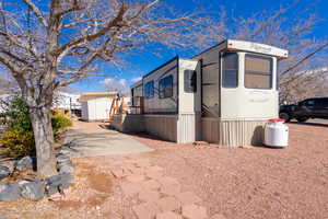 View of side of home with a shed, an outbuilding, and a patio