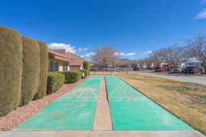 Surrounding community with shuffleboard, a yard, and a residential view