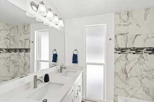 Full bath featuring toilet, a double sink vanity, and floor to ceiling window.