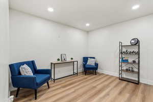 Sitting room with light LVP finished floors, and recessed lighting.