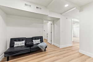 Sitting room with light LVP finished floors, and recessed lighting.