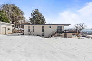 View of rear of property with central AC, shed, brick siding, and stairway to covered deck.