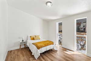 Bedroom with floor to ceiling windows, and LVP flooring.