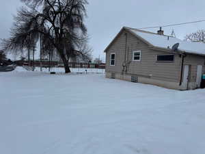 View of snow covered exterior featuring a chimney