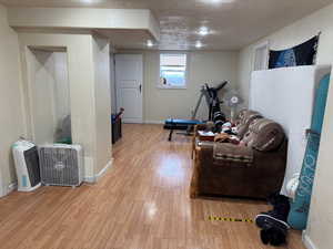 Interior space with light wood-type flooring, baseboards, and a textured ceiling