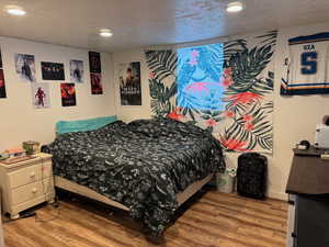 Bedroom with recessed lighting, a textured ceiling, and wood finished floors